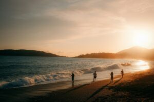 People walking on a beach at sunset